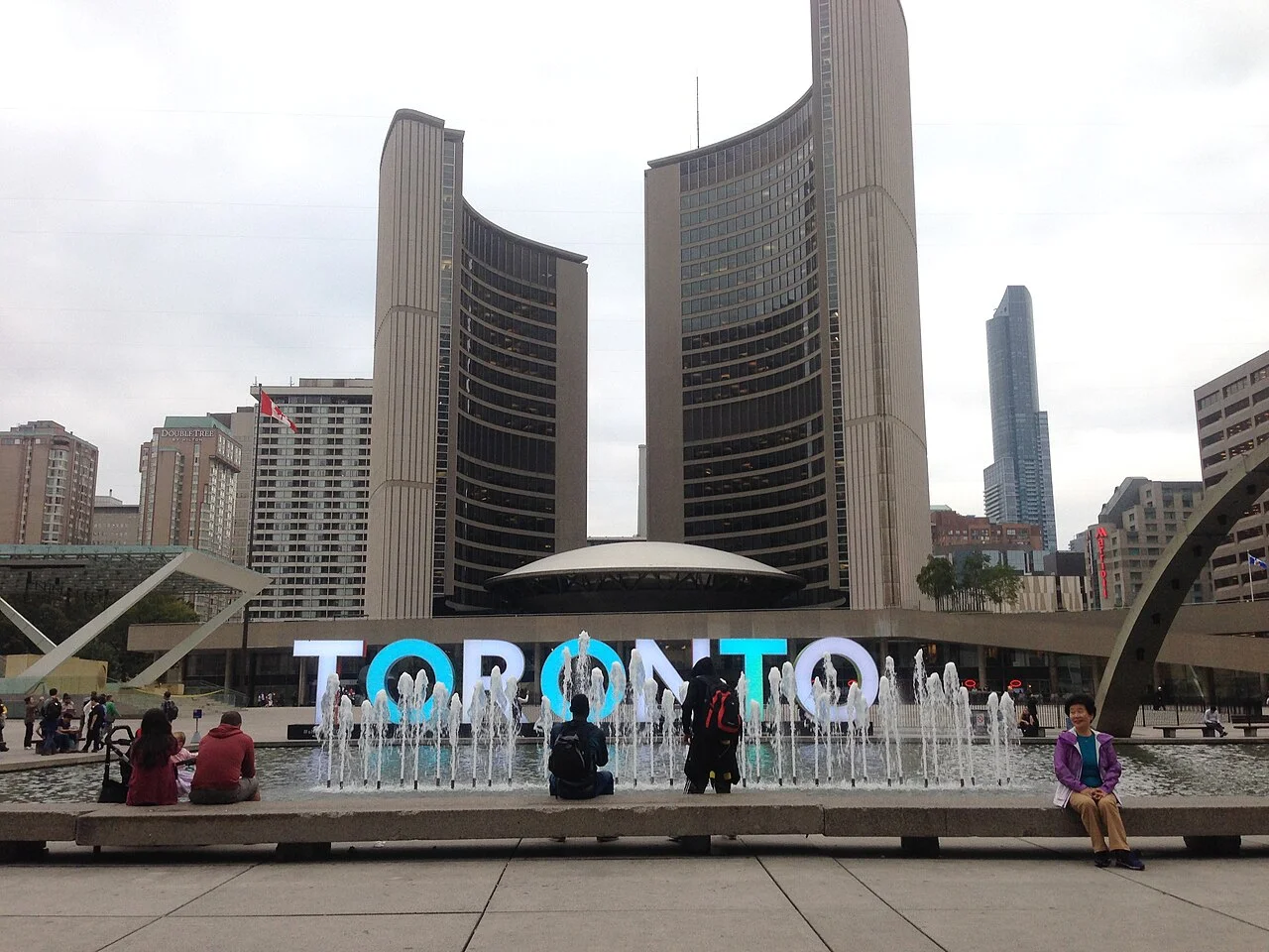 Toronto City Hall and the TORONTO sign seen across Nathan Phillips Square.