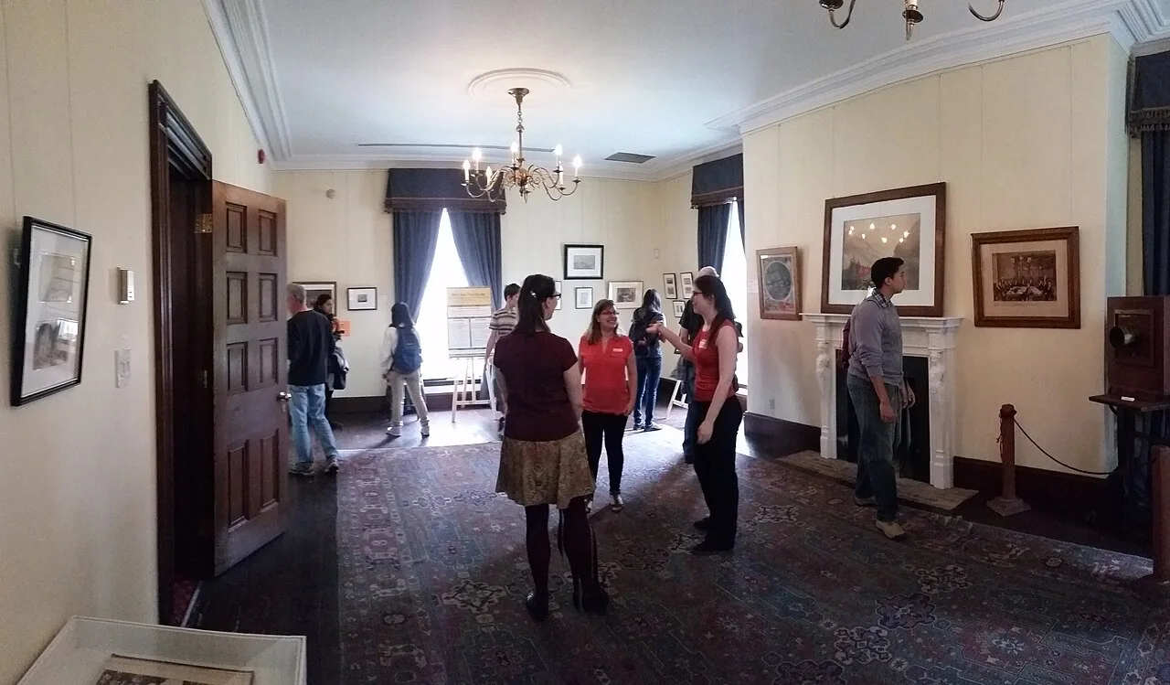 Visitors inside a furnished room at Campbell House Museum.