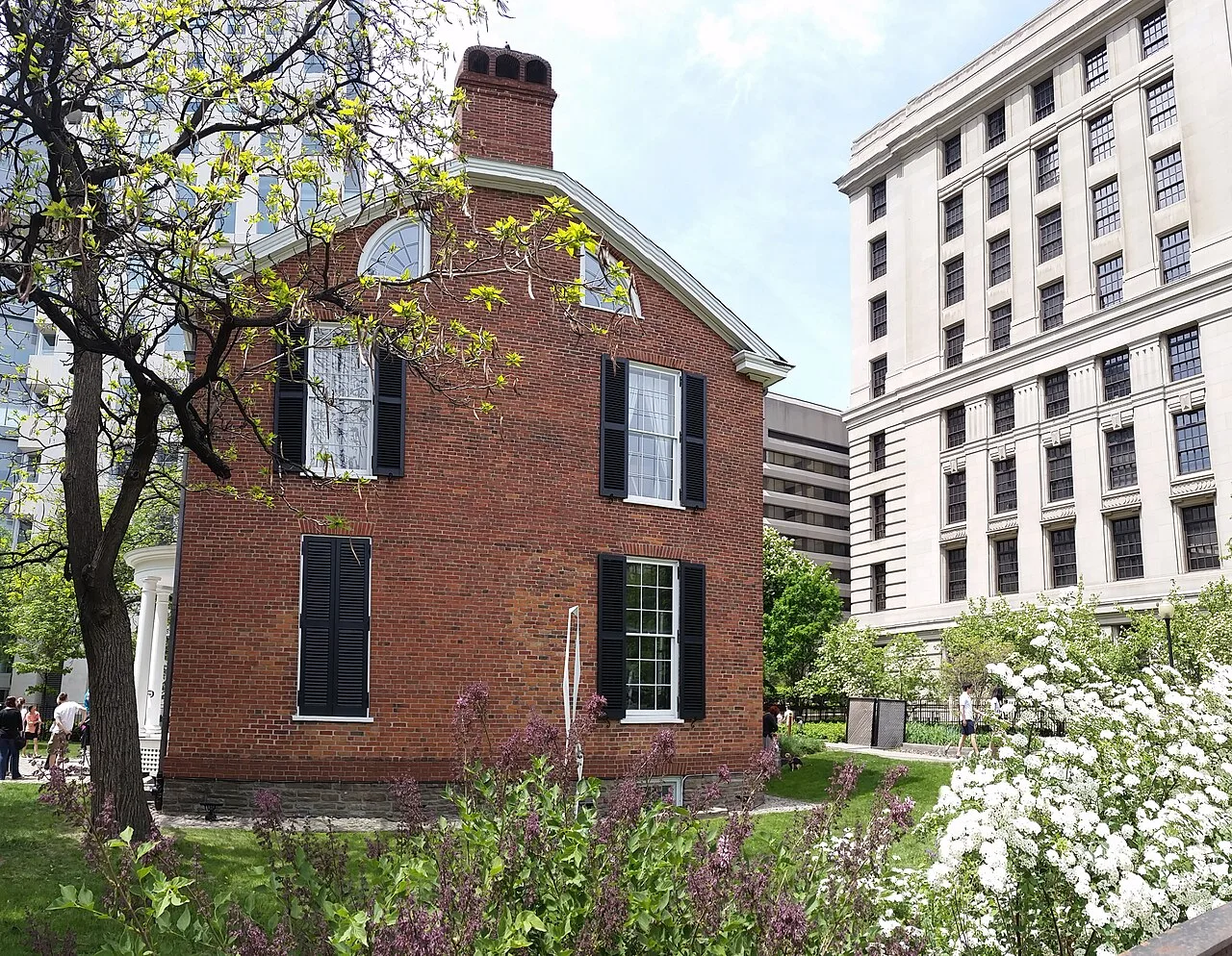 Campbell House side façade and garden beside a downtown office building.