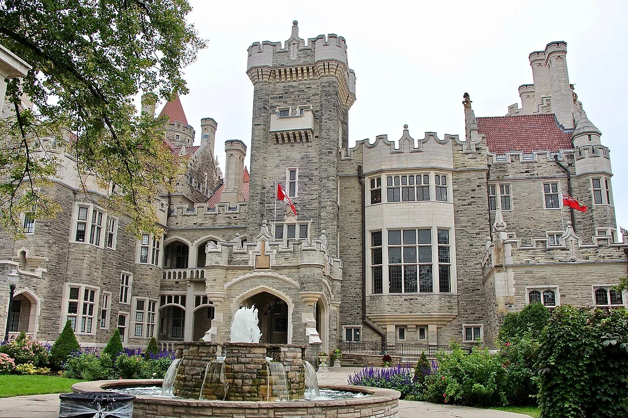 Casa Loma towers and stone exterior seen across a garden fountain.
