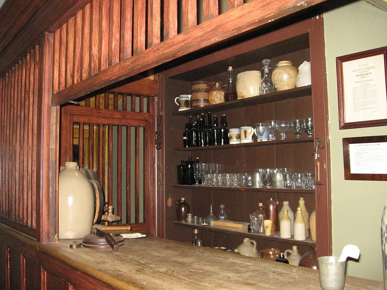 Historic bar counter with bottles and mugs at Montgomery’s Inn.