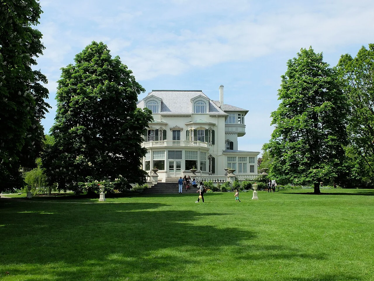 Lawn and garden with visitors outside Spadina House.