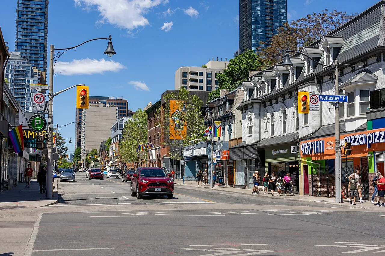 Church Street looking north from Wellesley with rainbow flags and storefronts