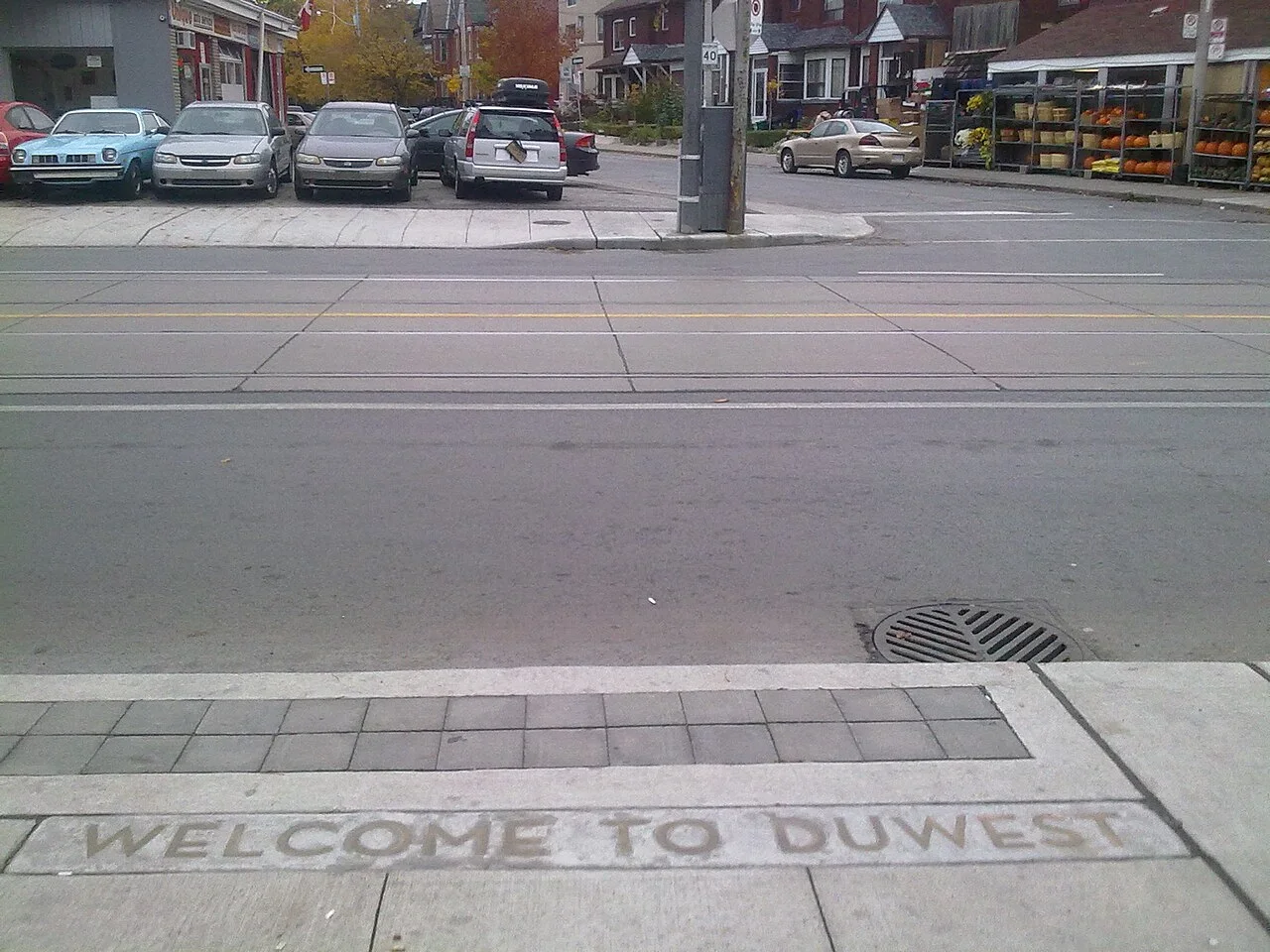 Dundas West streetscape with a welcome inscription in the sidewalk