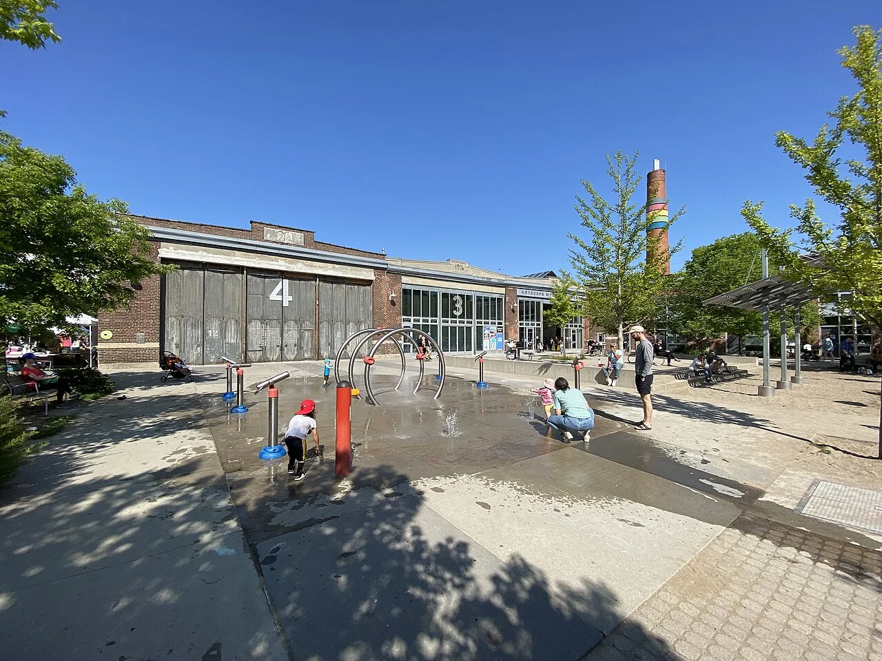 Wychwood Barns buildings and outdoor splash pad in summer