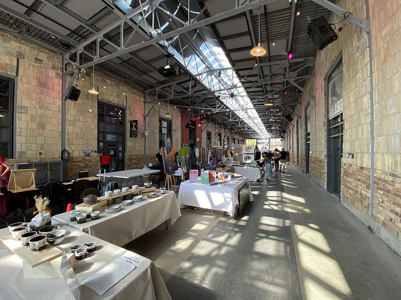 Long interior hall at Wychwood Barns with an art and craft display