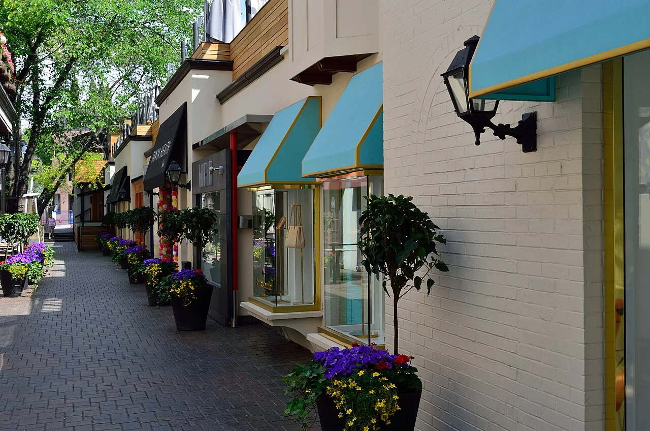 Pedestrian Old York Lane with small storefronts and planted containers