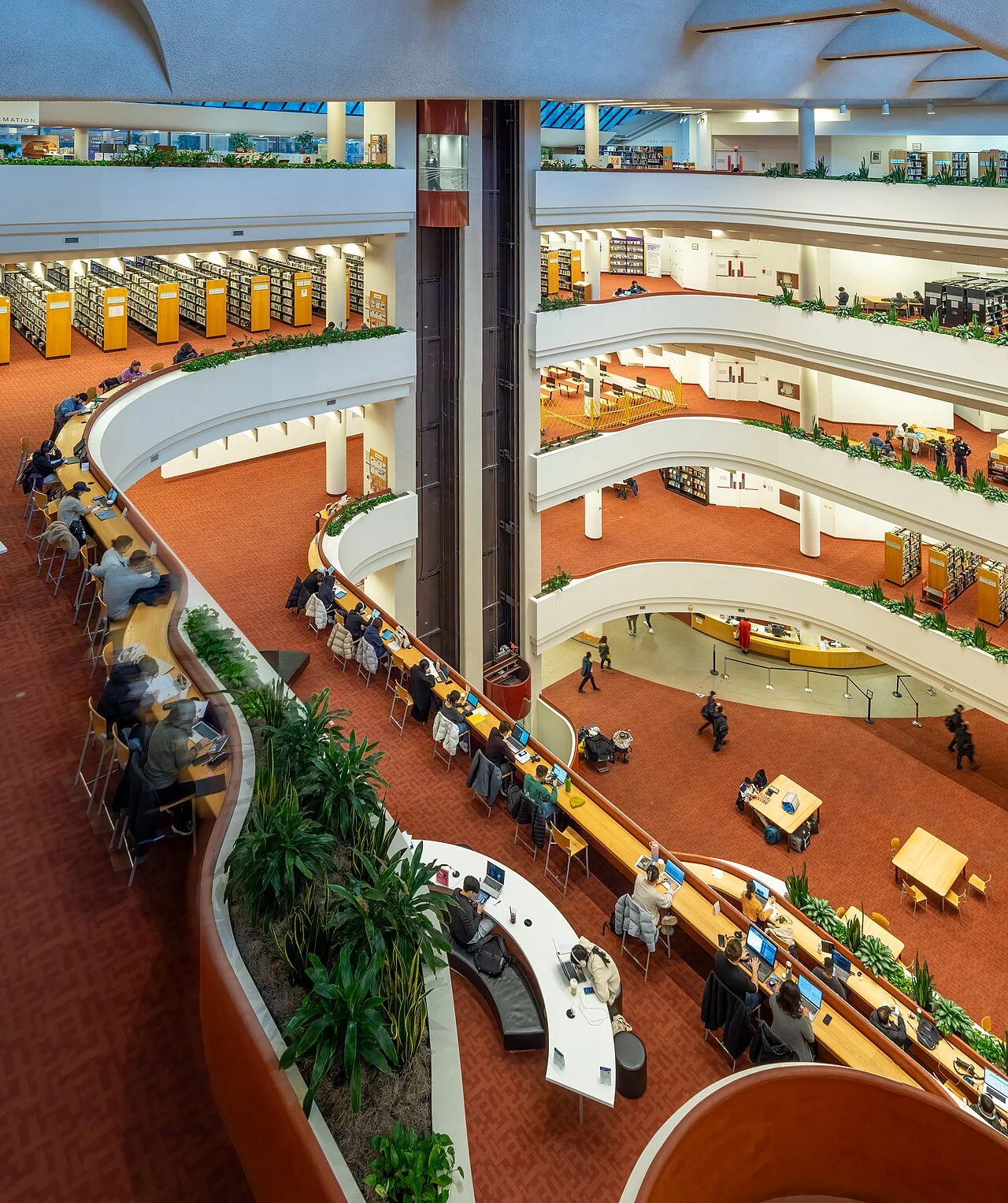 Visitors working at tables inside Toronto Reference Library.