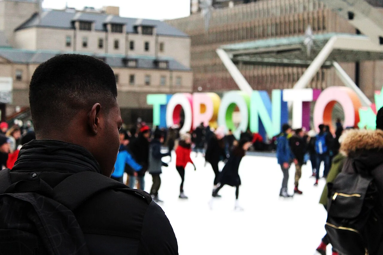 Skaters crossing the outdoor rink at Nathan Phillips Square.