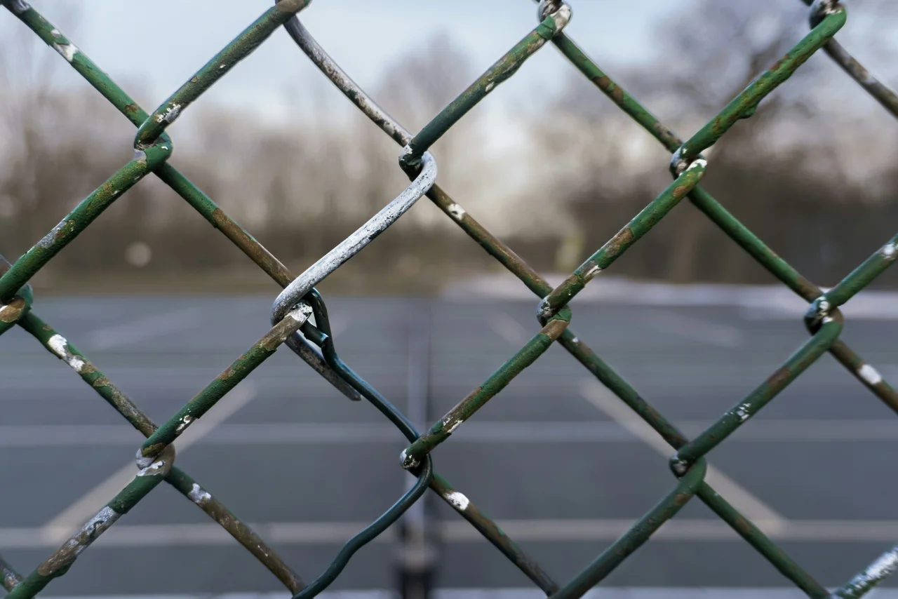 High Park tennis court seen through its chain-link fence.