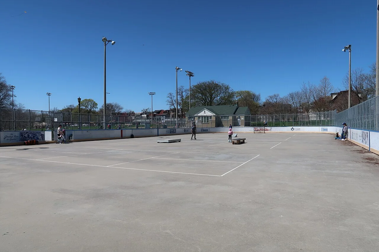 Trinity Bellwoods’ boarded rink surface without ice, used for warm-weather recreation.
