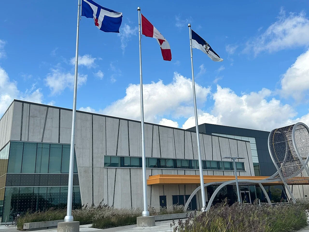 The exterior of Toronto Pan Am Sports Centre with flags and bicycle artwork.