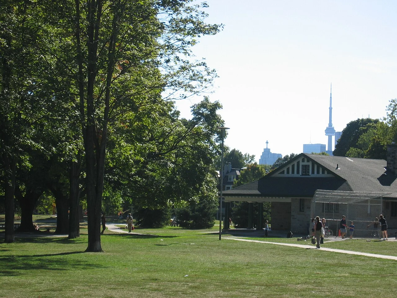 Mature trees and grass in Withrow Park, with the skyline beyond.