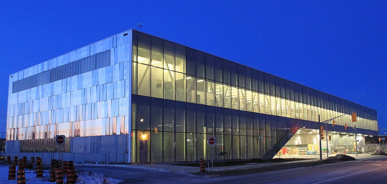 The illuminated glass and metal library building at Centennial College’s Ashtonbee campus at dusk.